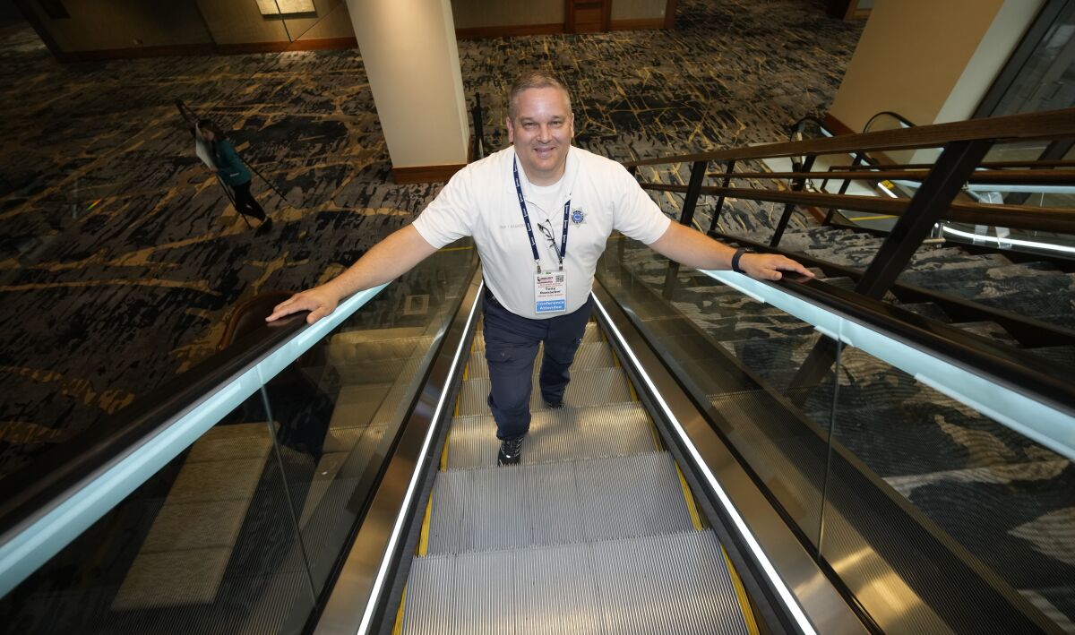 Student resource officer Tony Ramaeker, from Elkhorn, Neb., heads up an escalator while attending a convention, Tuesday, July 5, 2022, in Denver. (AP Photo/David Zalubowski)