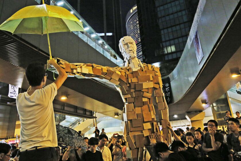 A statue holding a yellow umbrella, a symbol of the protest, stands outside the government headquarters in Hong Kong.