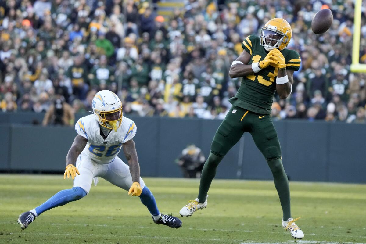 Packers receiver Dontayvion Wicks (13) is unable to make a catch as  Chargers cornerback Asante Samuel Jr. (26) defends.