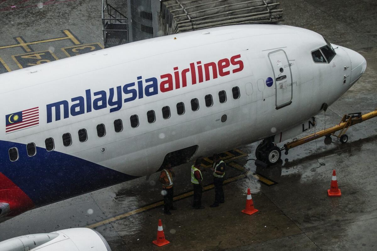 A Malaysia Airlines crew works near on an aircraft at Kuala Lumpur International Airport on Aug 8.