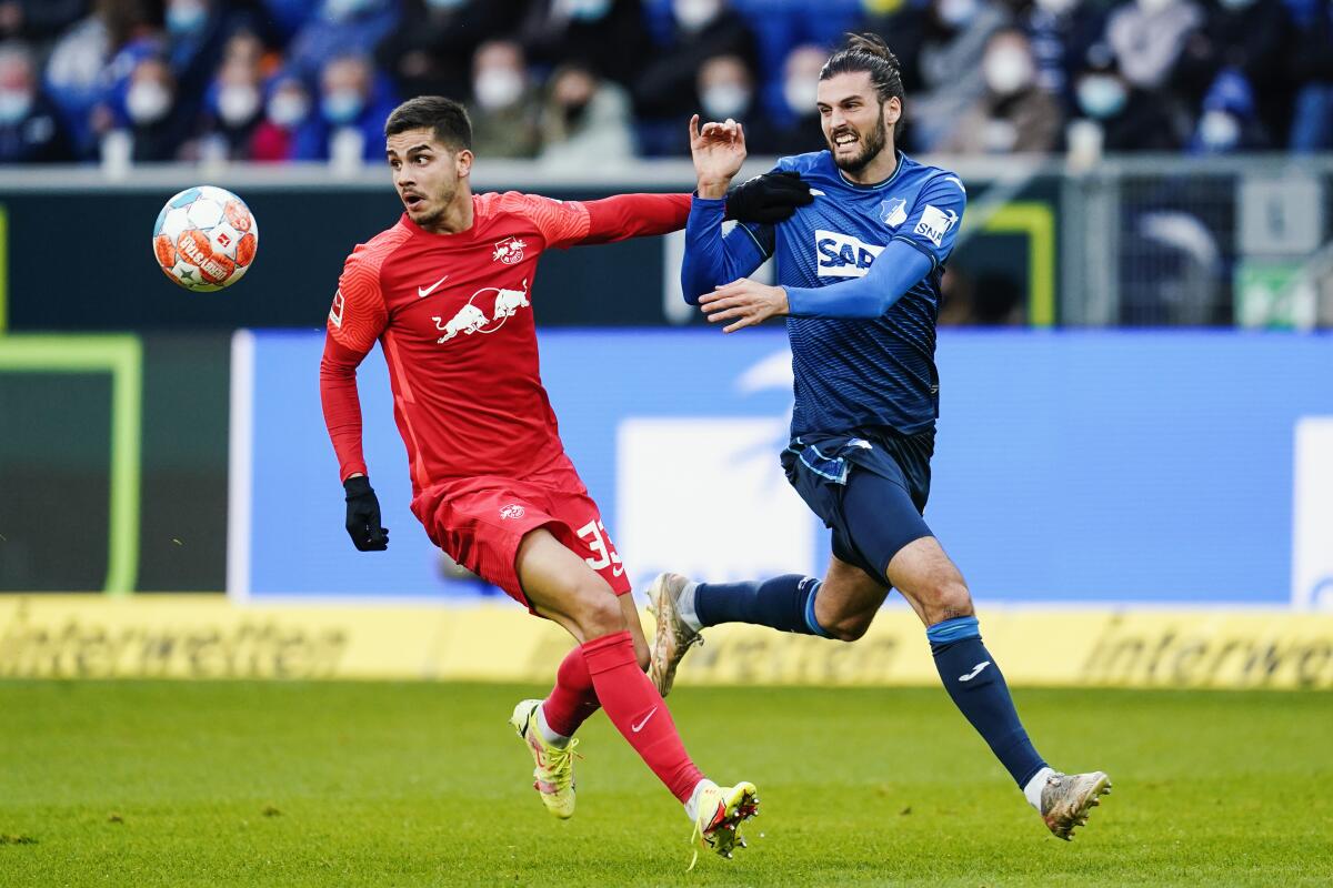 Leipzig's Andre Silva, left, and Hoffenheim's Florian Grillitsch fight for the ball during a German Bundesliga soccer match between TSG 1899 Hoffenheim and RB Leipzig in Sinsheim, Germany, Saturday, Nov.10, 2021. (Uwe Anspach/dpa via AP)