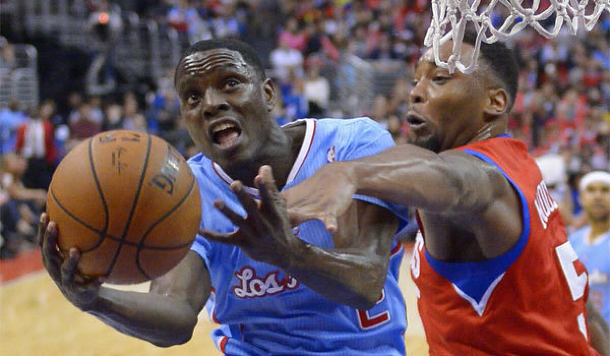 Clippers guard Darren Collison, left, goes up for a shot against Philadelphia forward Arnett Moultrie at Staples Center in downtown Los Angeles.