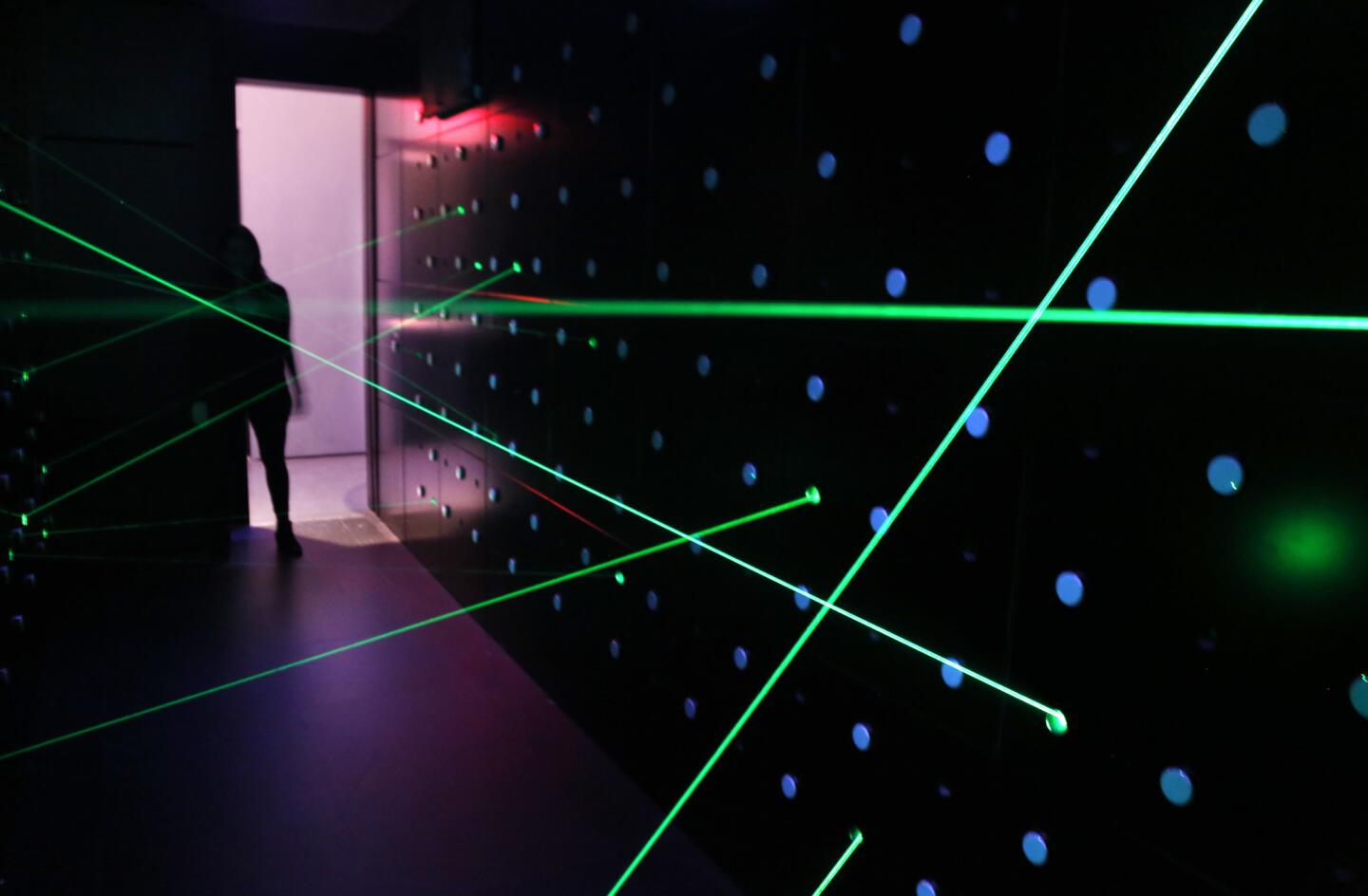 Lasers fill a room that challenges visitors to pass through without touching them at SPYSCAPE in New York.