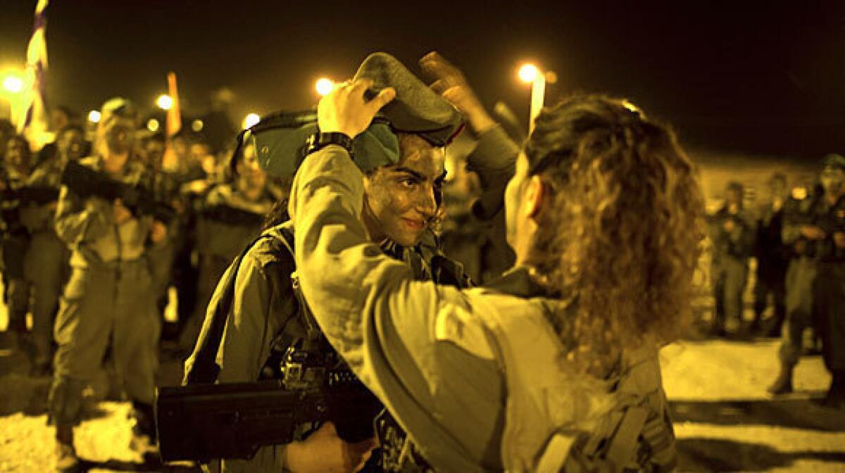 An Israeli female soldier receives her graduation cap after a march in the Negev desert this month.