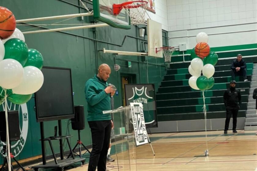 Marlon Garnett addresses spectators at Hamilton High during a ceremony to retire his uniform number.