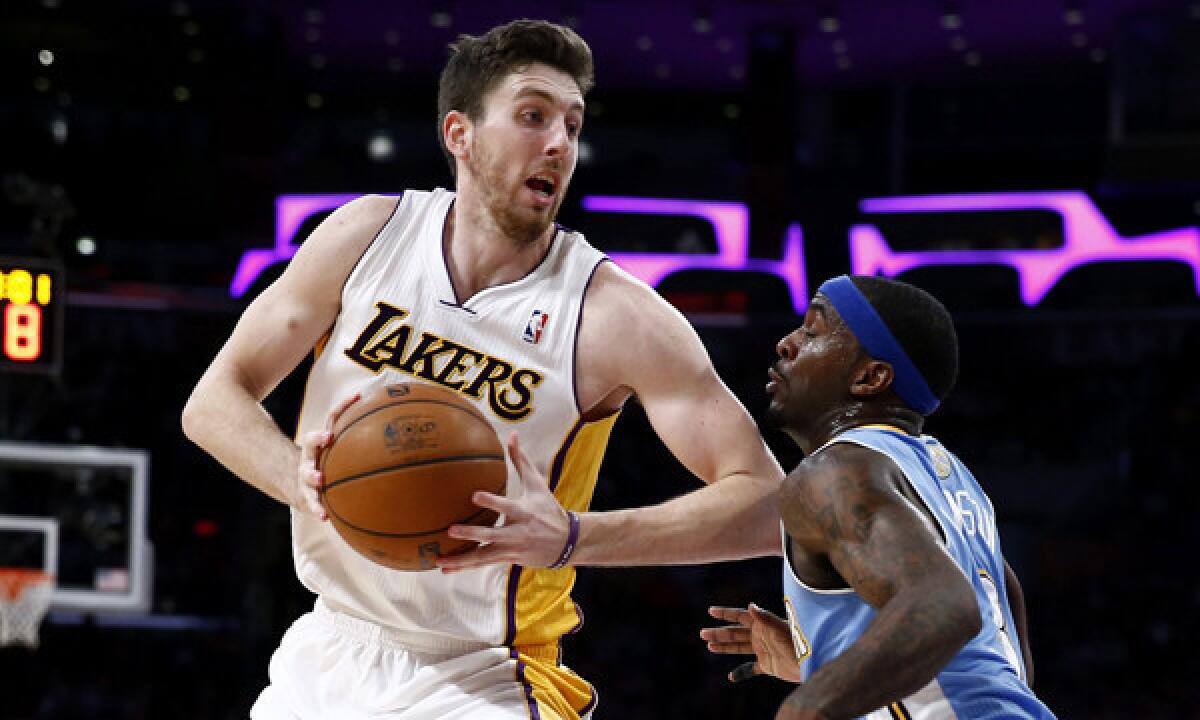 Lakers forward Ryan Kelly tries to maneuver past Denver Nuggets guard Ty Lawson during a Jan. 5 loss.