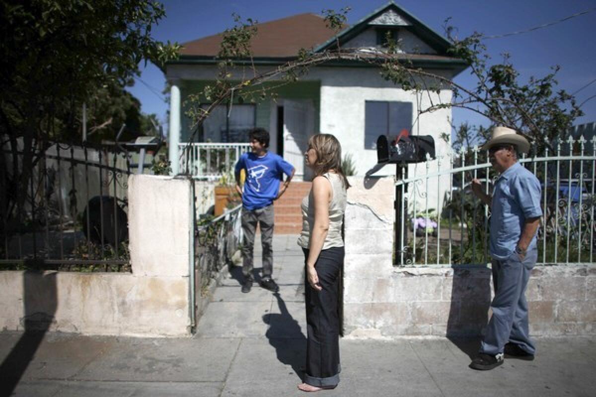 Adela Barajas, center, outside the family home on Long Beach Avenue. Her brother was shot and stabbed near here, and her sister-in-law was gunned down.