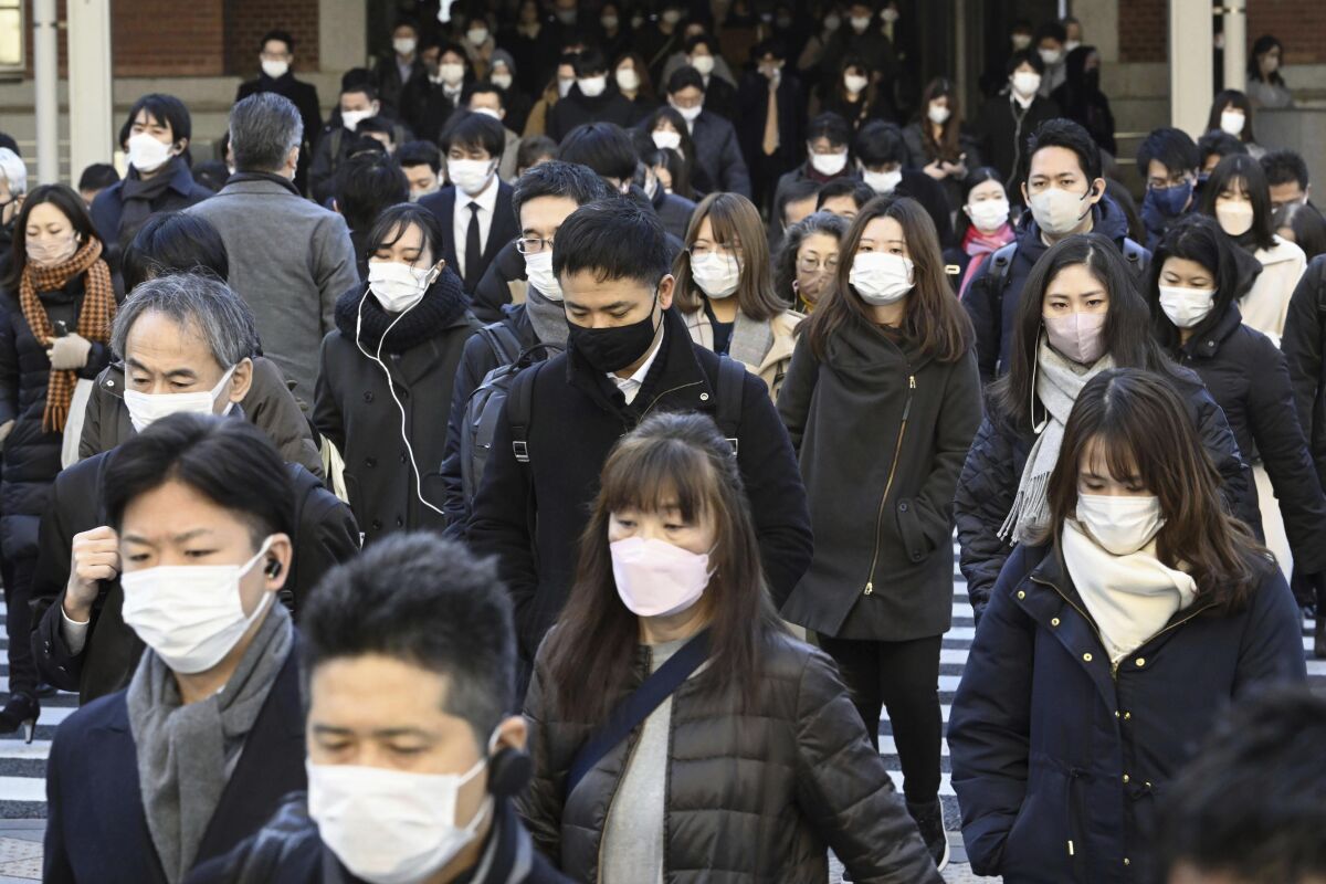 Usuarios usan mascarillas al salir de la Estación Tokio, el viernes 20 de enero de 2023, en Tokio. (Kyodo News vía AP)