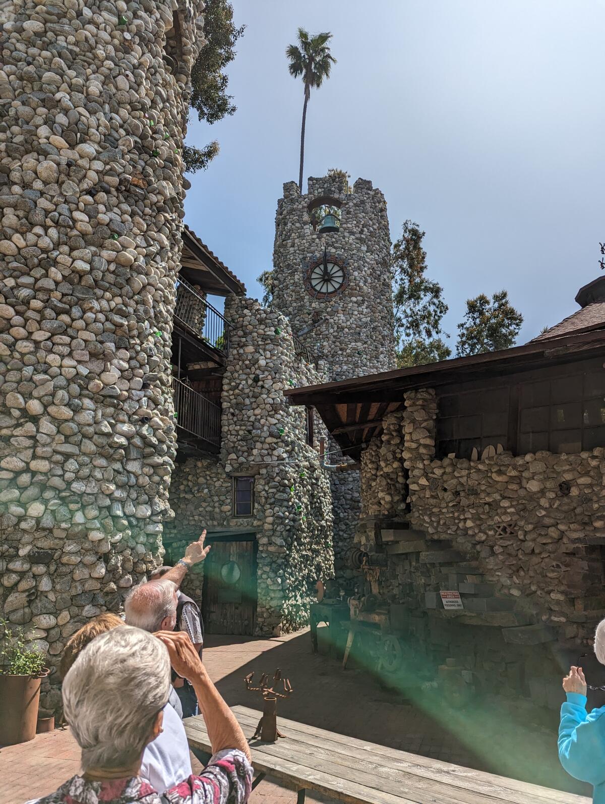 People look at the exterior of stone-covered Rubel Castle
