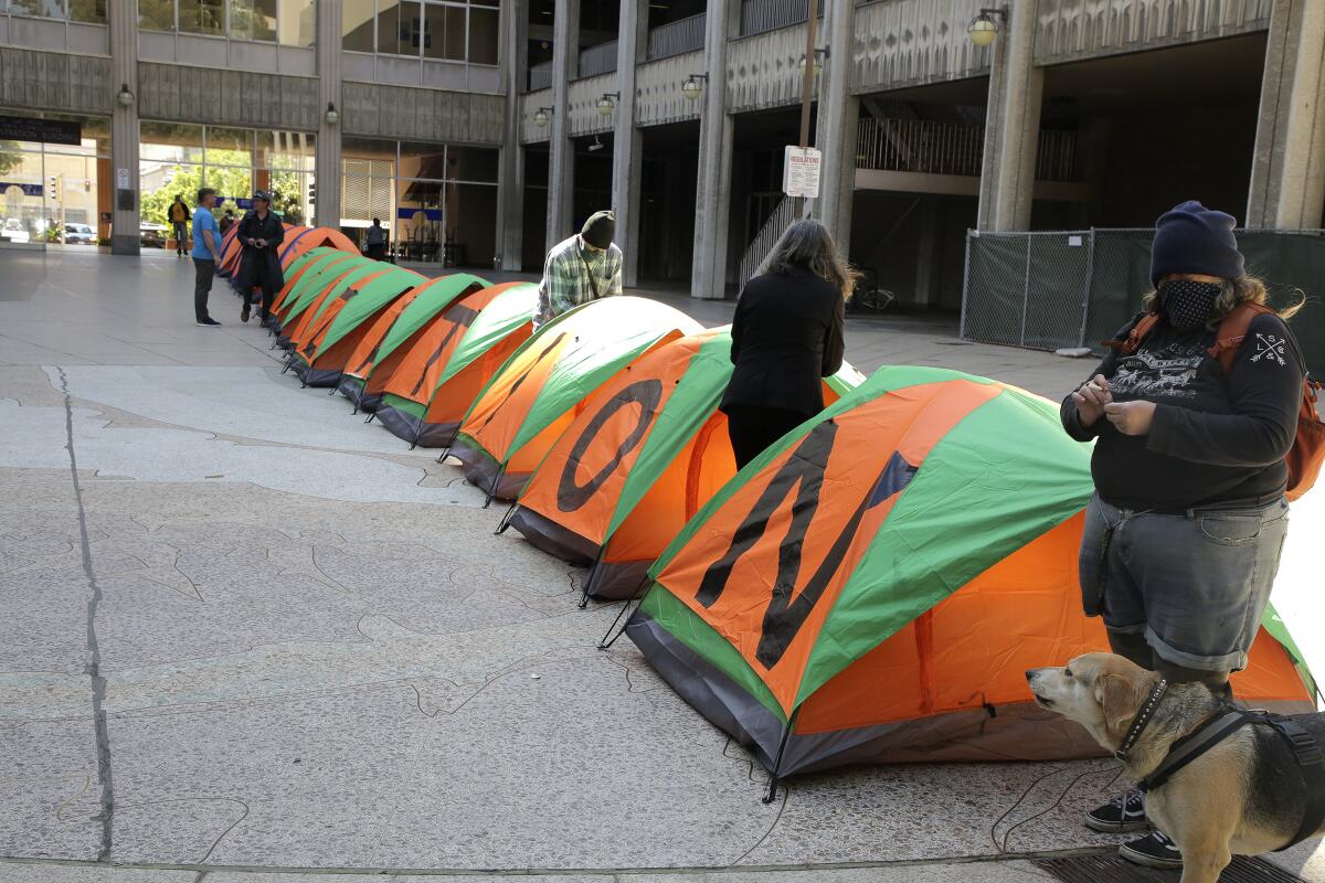 San Diego homeless people and their advocates set up tents during a homeless vigil at the San Diego Concourse on Tuesday.