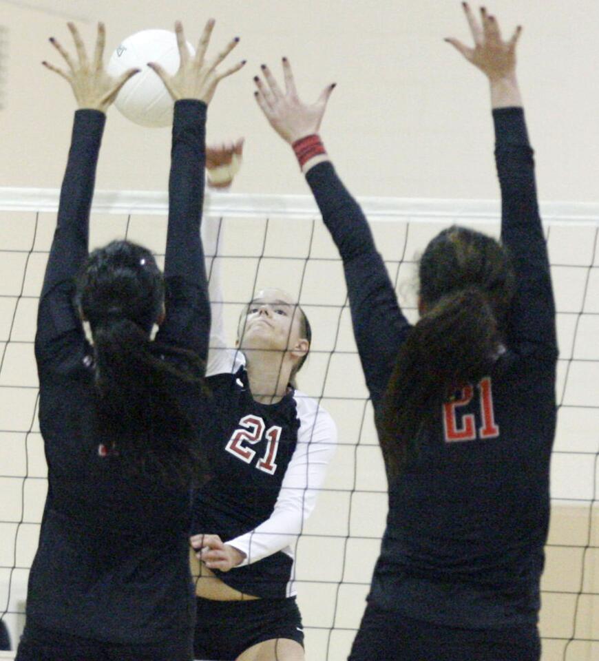 FSHA's Katie Conley, center, spikes the ball during a match against Harvard-Westlake at FSHA in La Canada l on Tuesday, October 2, 2012.