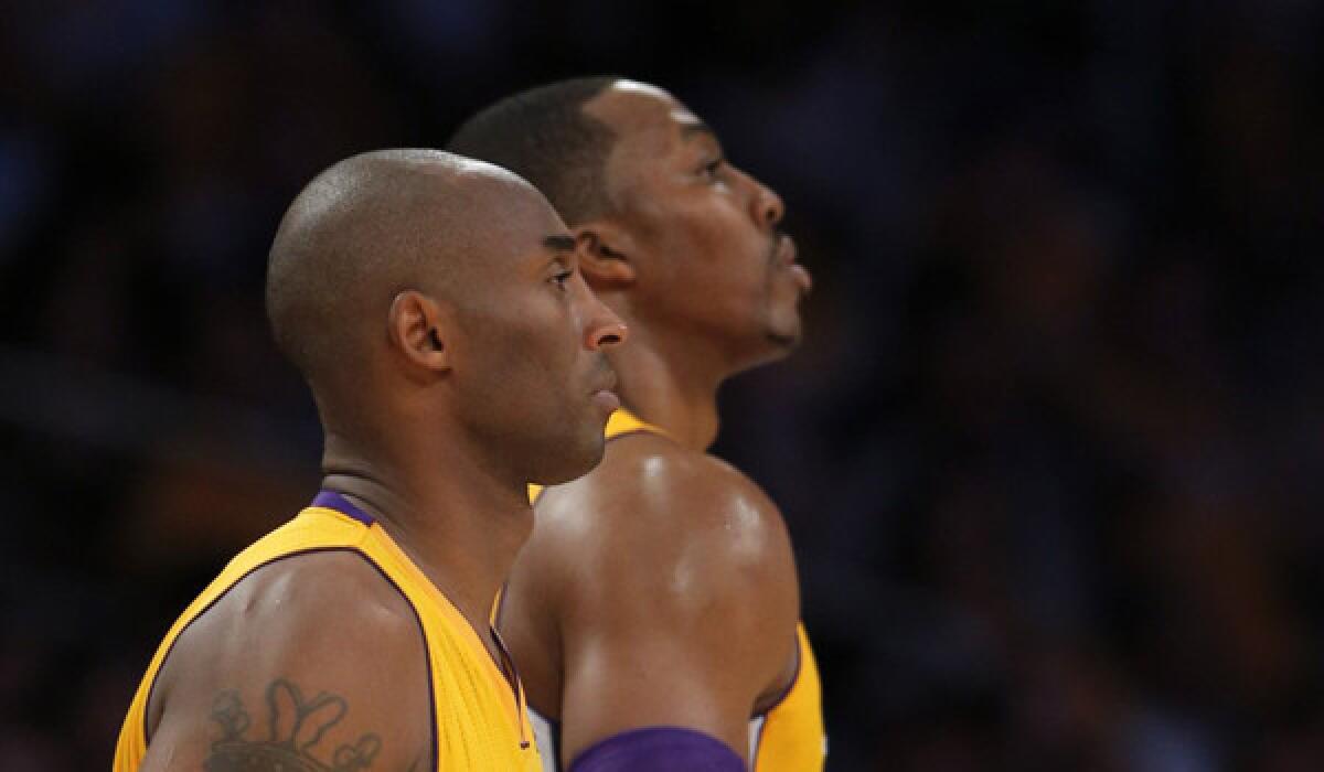 Guard Kobe Bryant, left, and Dwight Howard, rear right, watch during the second half during the Lakers' 99-91 loss to the Mavericks on Tuesday.