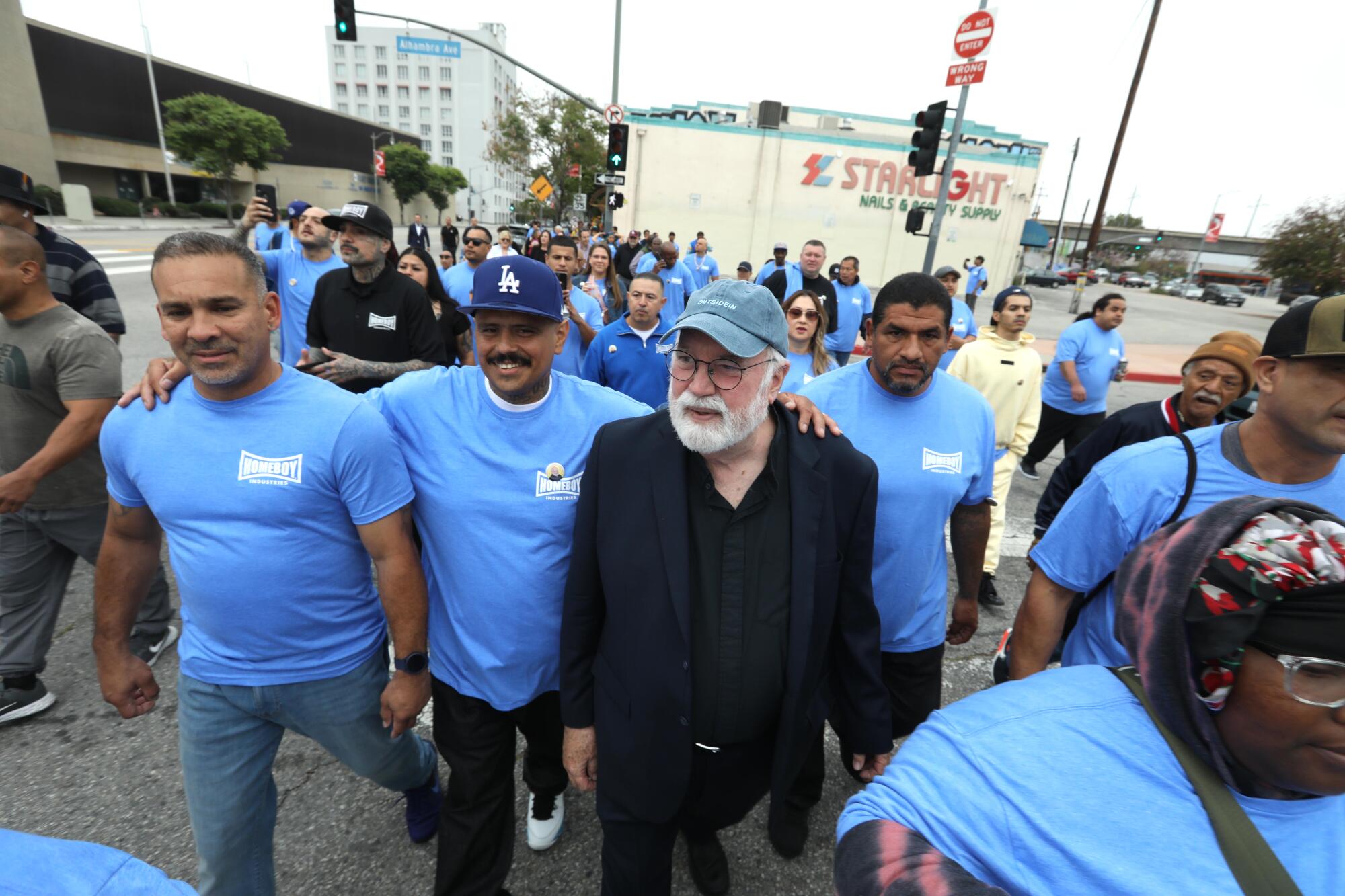 Father Greg Boyle, center, marches to City Hall from Homeboy Industries with staff and program enrollees.