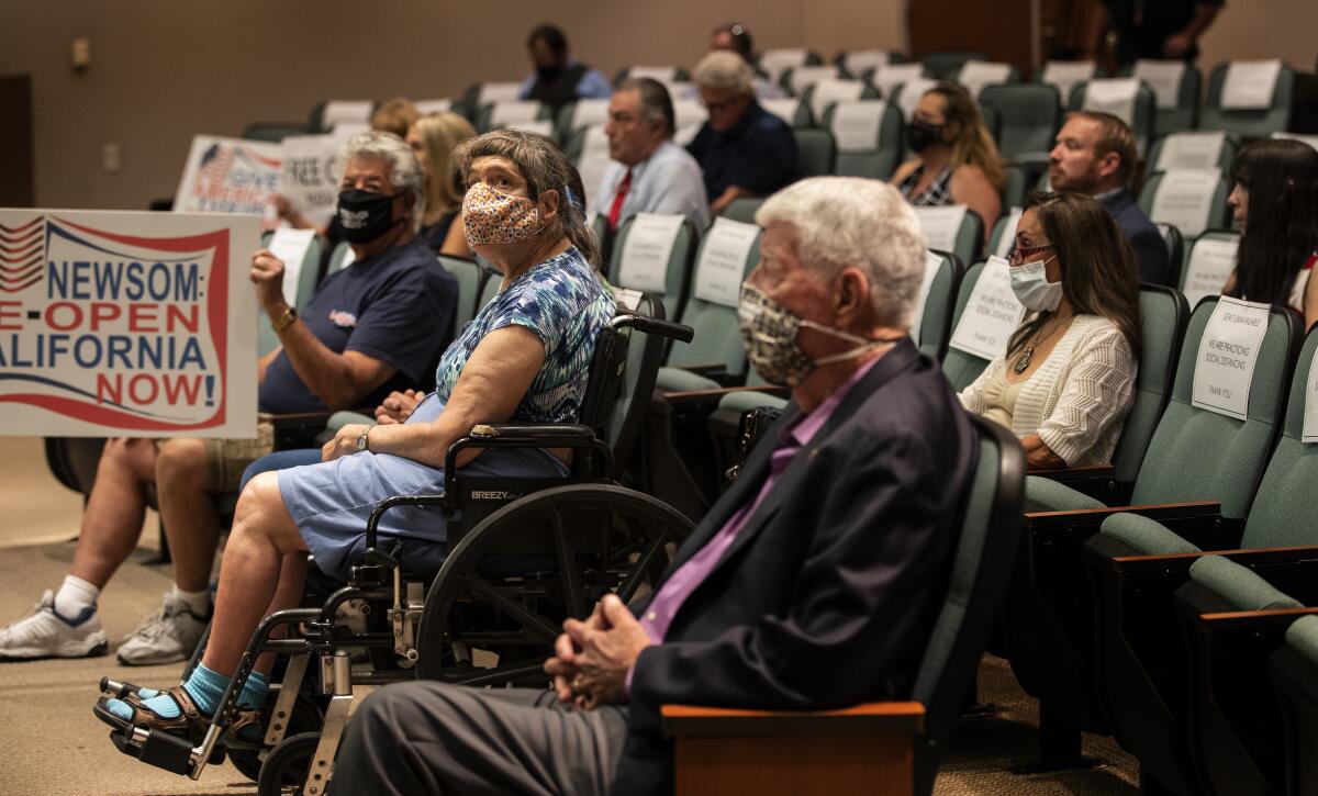 Residents attend an emergency meeting of the Riverside County Board of Supervisors at the County Administrative Center in Riverside. Printed notices are placed on chairs to keep people spaced appropriately.