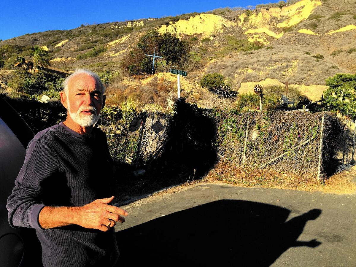 Mike Bell started the La Conchita Community Organization after the 2005 landslide that killed 10 residents. Behind him, crosses commemorate the victims.