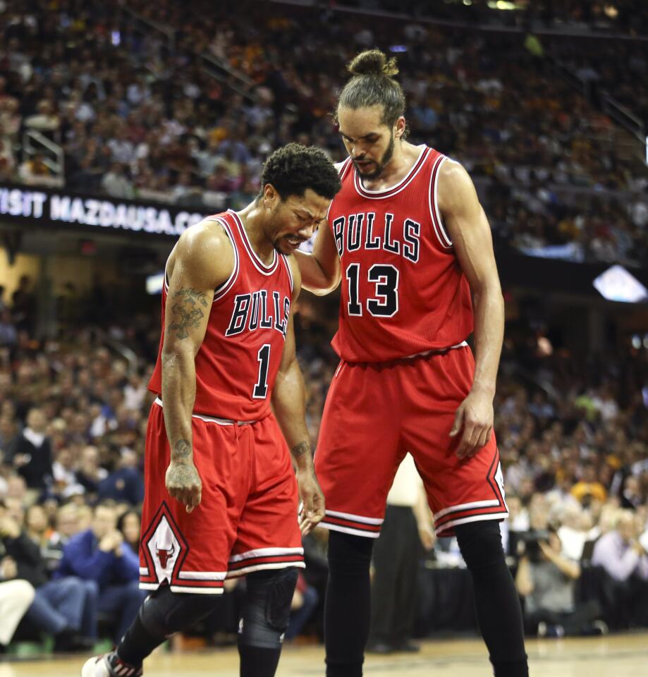 Bulls guard Derrick Rose grimaces in pain as he walks with teammate Joakim Noah during the second half.