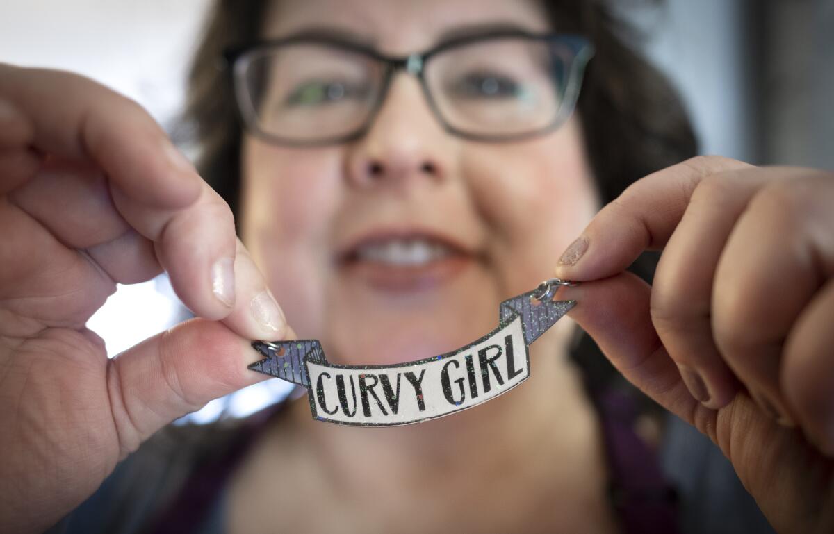 Chrystal Bougon sostiene un cartel que dice "chica con curvas". 