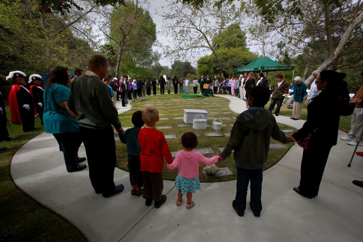In 2012, Garden of Innocence volunteers perform a memorial burial ceremony at El Camino Memorial Cemetery for abandoned baby Coraann, a name given to her by the family of volunteers who provide the coffin, a toy, a poem, hand-made quilt, flowers, doves and music for her memorial service.