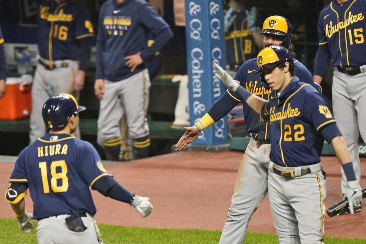Milwaukee Brewers' Keston Hiura (18) is congratulated by teammates after hitting a two-run home run in the eighth inning in a baseball game against the Cleveland Indians, Friday, Sept. 4, 2020, in Cleveland. (AP Photo/Tony Dejak)