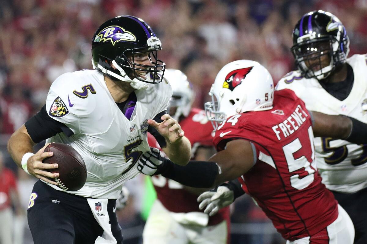 Baltimore quarterback Joe Flacco avoids a tackle by Arizona's Kenny Demens on Monday night.