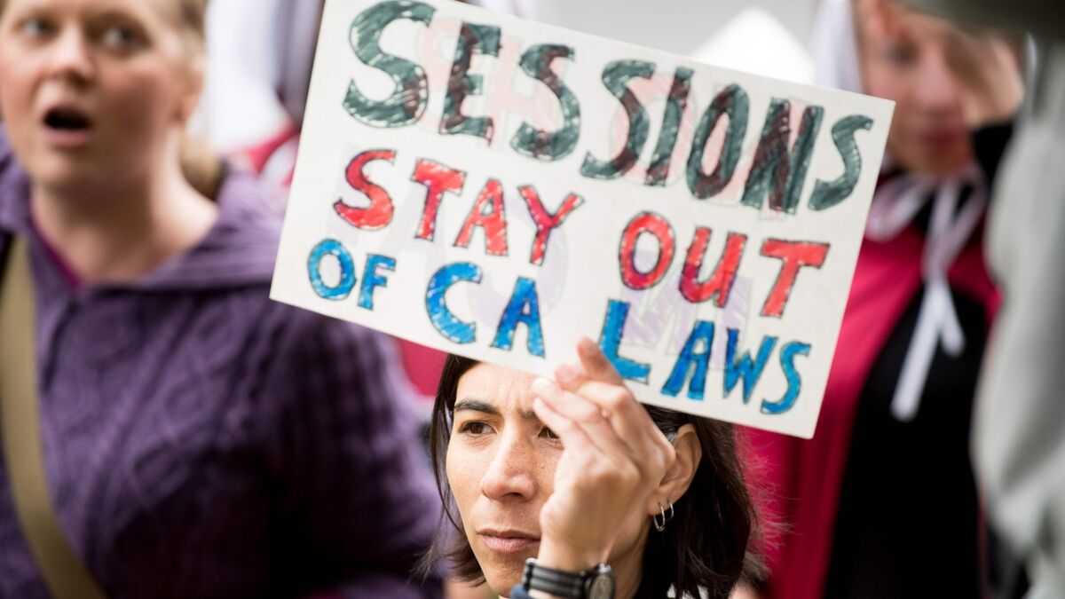 People protest outside a speech by U.S. Atty. Gen. Jeff Sessions on Wednesday in Sacramento, where he admonished state politicians for not cooperating with federal authorities on immigration enforcement issues.