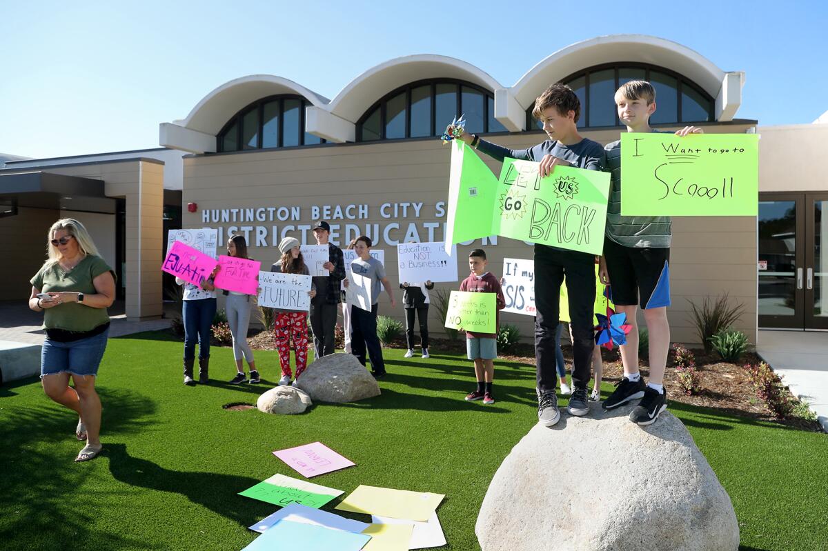 Students and parents protest in front of the Huntington Beach City School District office on Wednesday morning. 