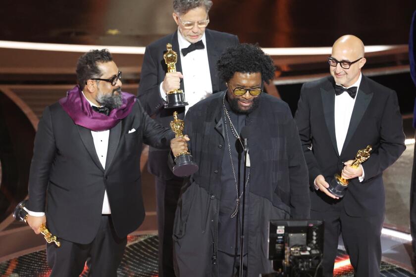 HOLLYWOOD, CA - March 27, 2022. Ahmir "Questlove" Thompson in the center accepts the award for for Best documentary feature nominees for "Summer of Soul" onstage during the show at the 94th Academy Awards at the Dolby Theatre at Ovation Hollywood on Sunday, March 27, 2022. (Myung Chun / Los Angeles Times)