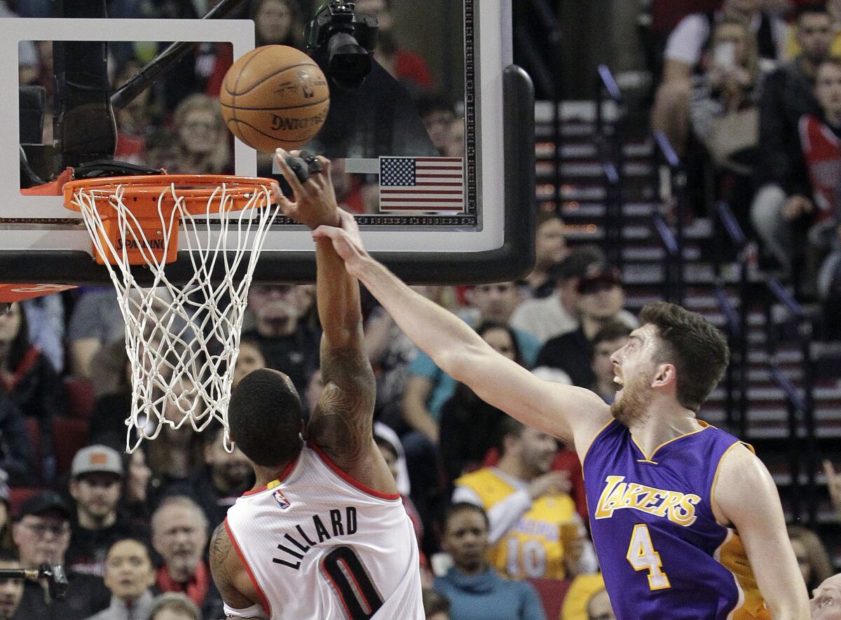 Lakers forward Ryan Kelly commits a foul as he tries to block a shot by Trail Blazers point guard Damian Lillard during a Jan. 5 game in Portland.