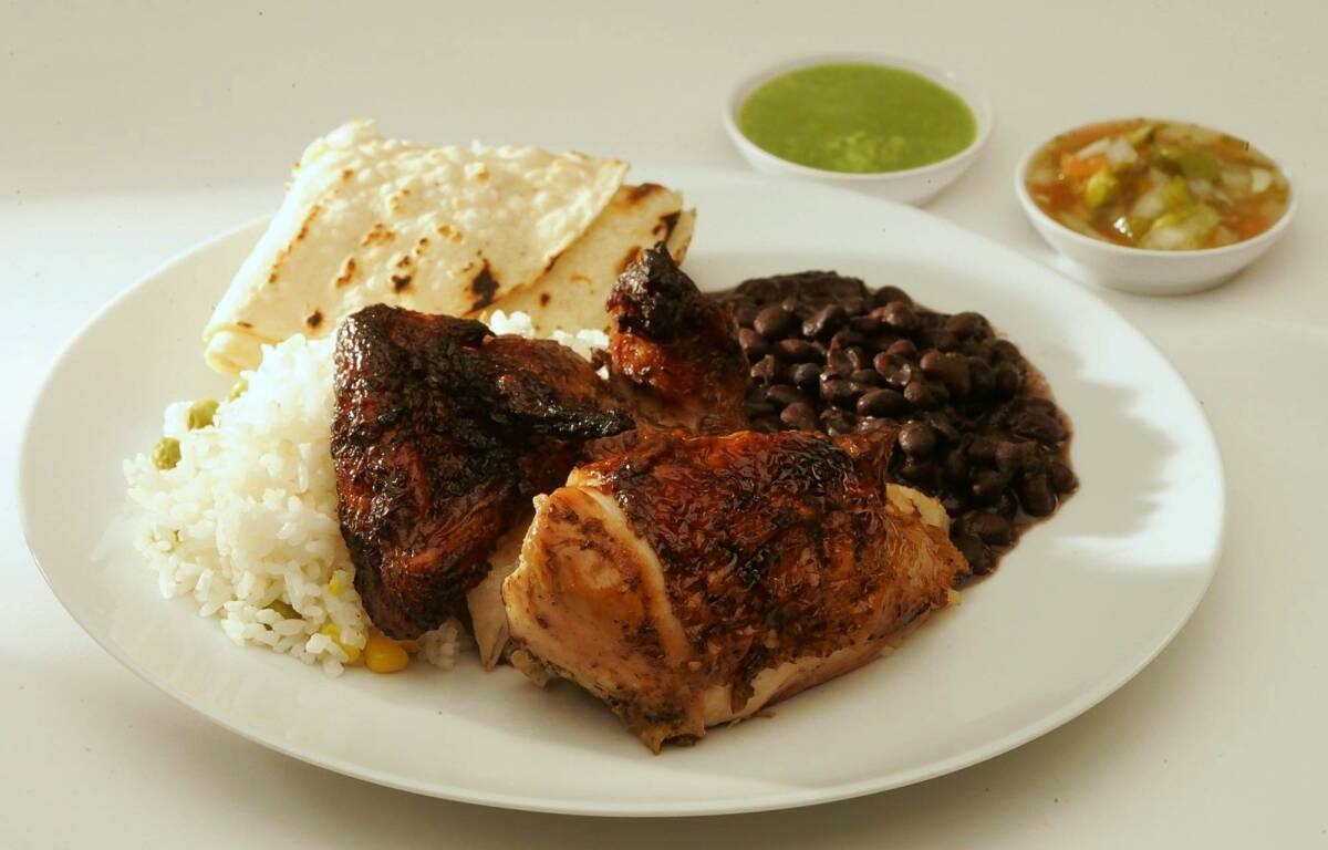 Chicken from Pollo a la Brasa is wood-roasted. You can get rice and beans on the side.