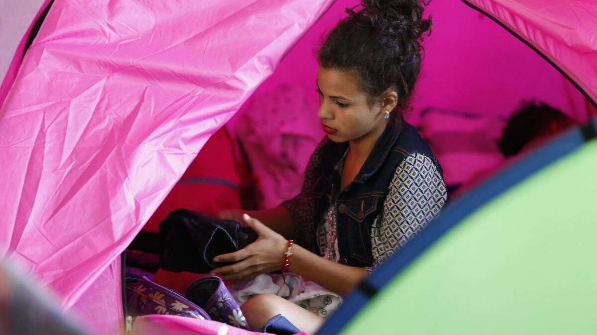 Angie, who came from Honduras with the recent migrant caravan, packs clothes in her tent at the Movimiento Juventud 2000 shelter in Zona Norte. Many from the caravan are expected to ask for asylum on Sunday.