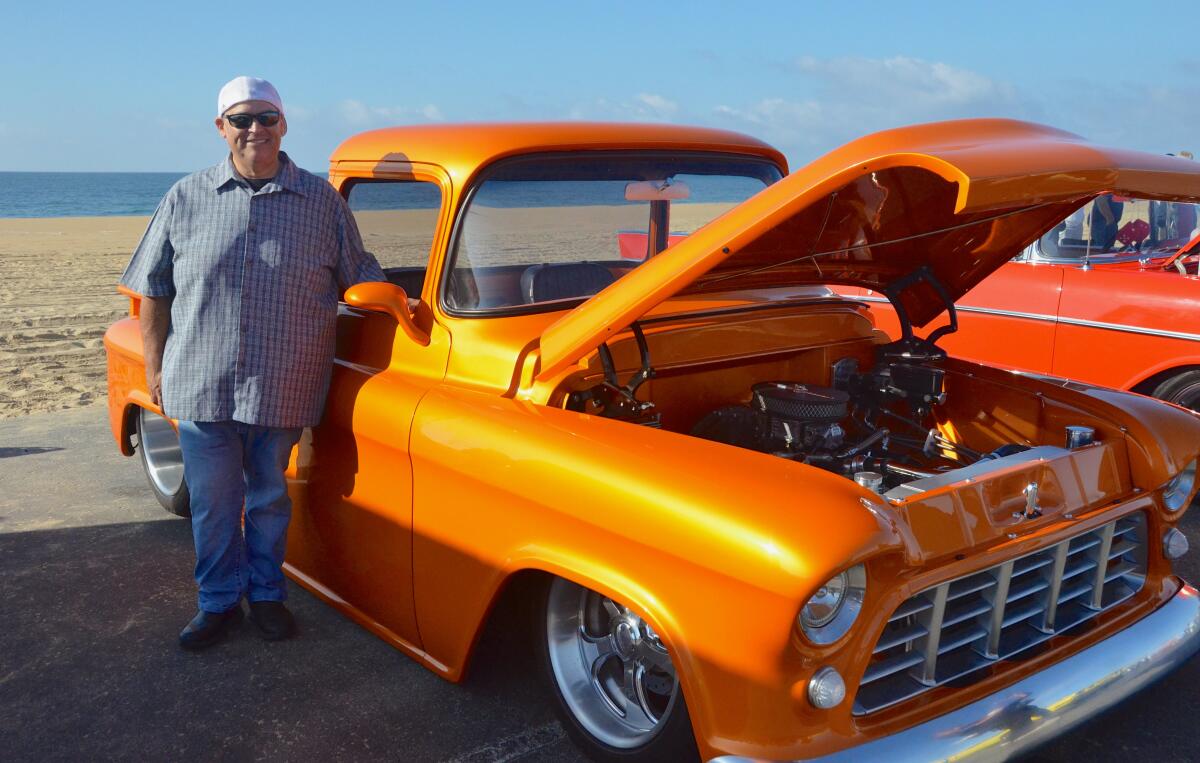 Anthony Gutierrez stands with his "sunset orange" 1955 Chevy Apache truck.