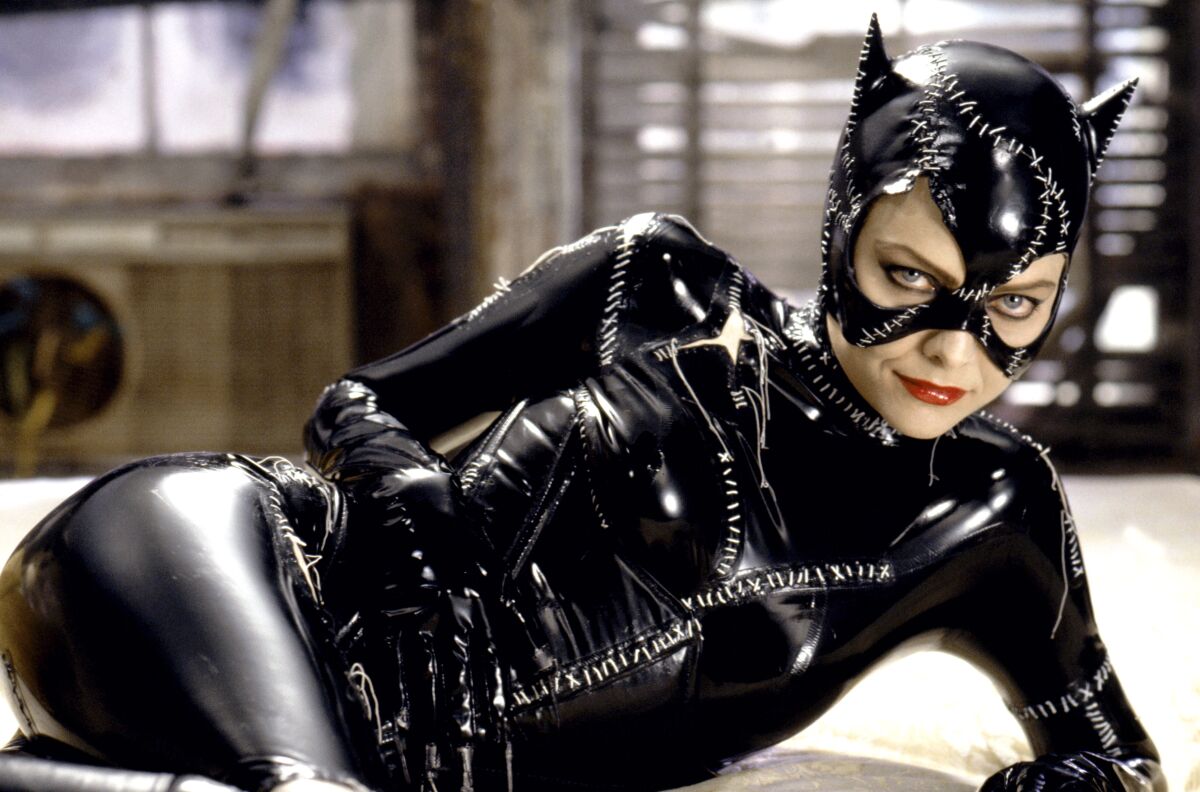 Catwoman reclines in a black mask and bodysuit.