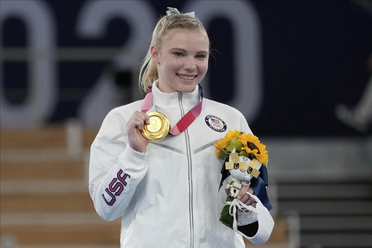 U.S. gymnast Jade Carey smiles and holds up her gold medal.