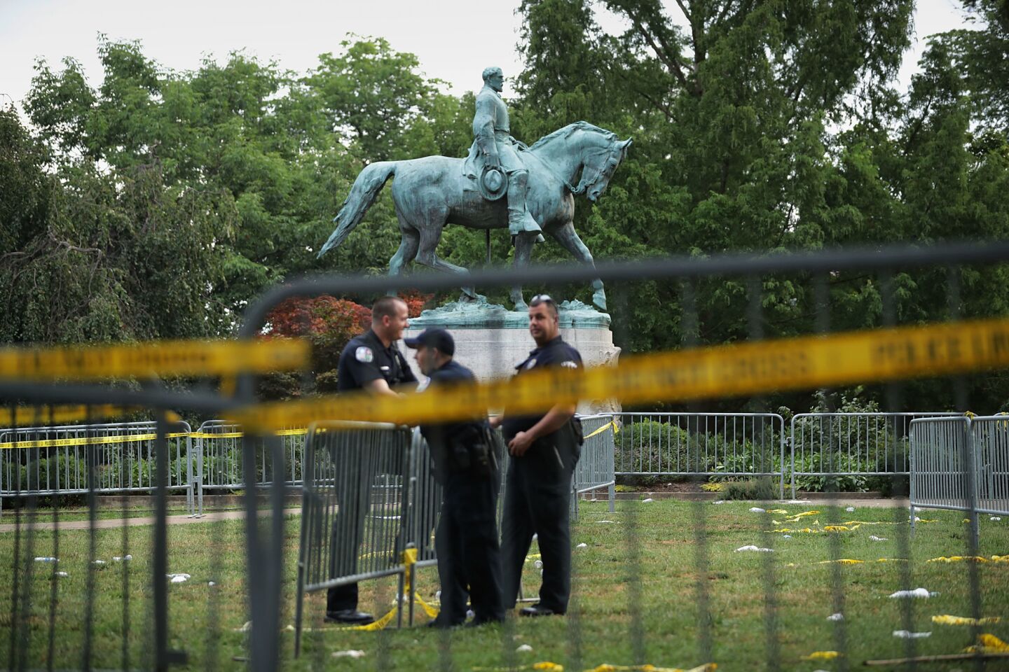 Police stand watch Sunday near the statue of Confederate Gen. Robert E. Lee in the center of Emancipation Park in Charlottesville, Va. White nationalists rallied in the city in part to protest the pending removal of the statue.