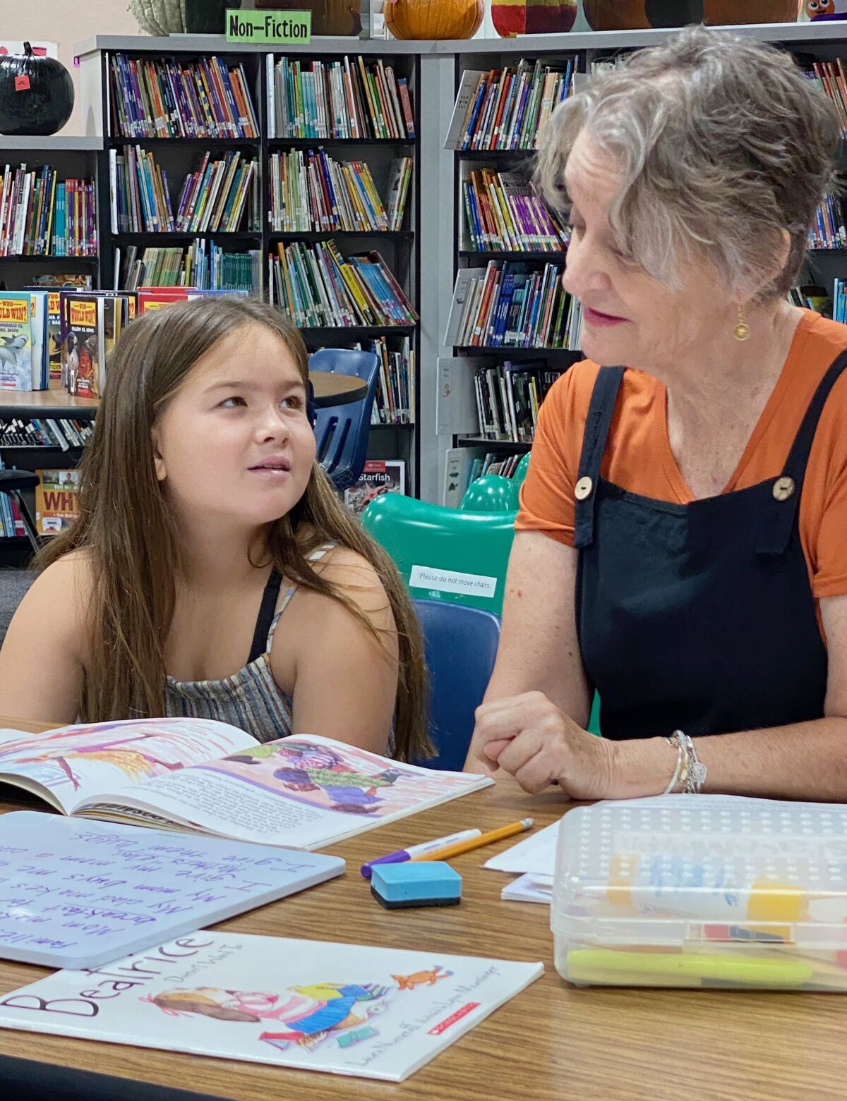 Barnett Elementary third-grader Allyson Juvenal gets instruction from Oasis tutor Tracey McFarland.
