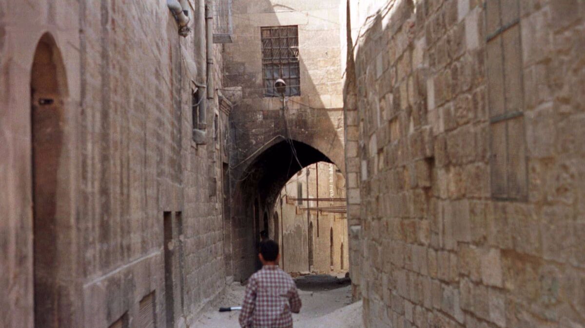 A boy cycles through the narrow alleys of the old city of Aleppo, north of Damascus, Syria, in June 1998.