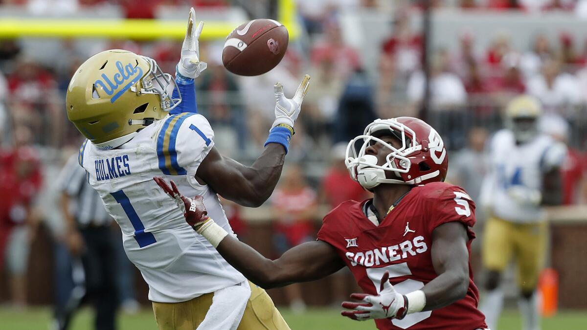 UCLA cornerback Darnay Holmes intercepts a pass intended for Sooners receiver Marquise Brown during a game Sept. 14 at the Rose Bowl.