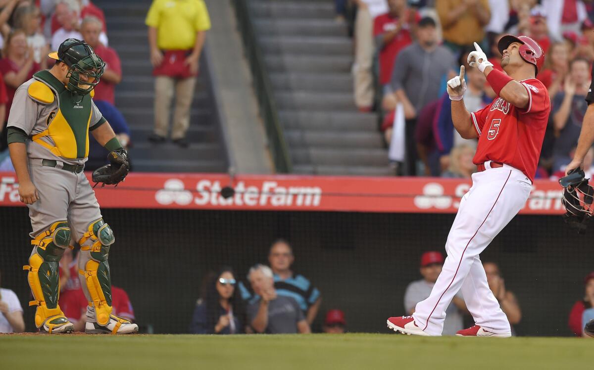 Albert Pujols celebrates after hitting a solo home run during the first inning Saturday against Oakland.