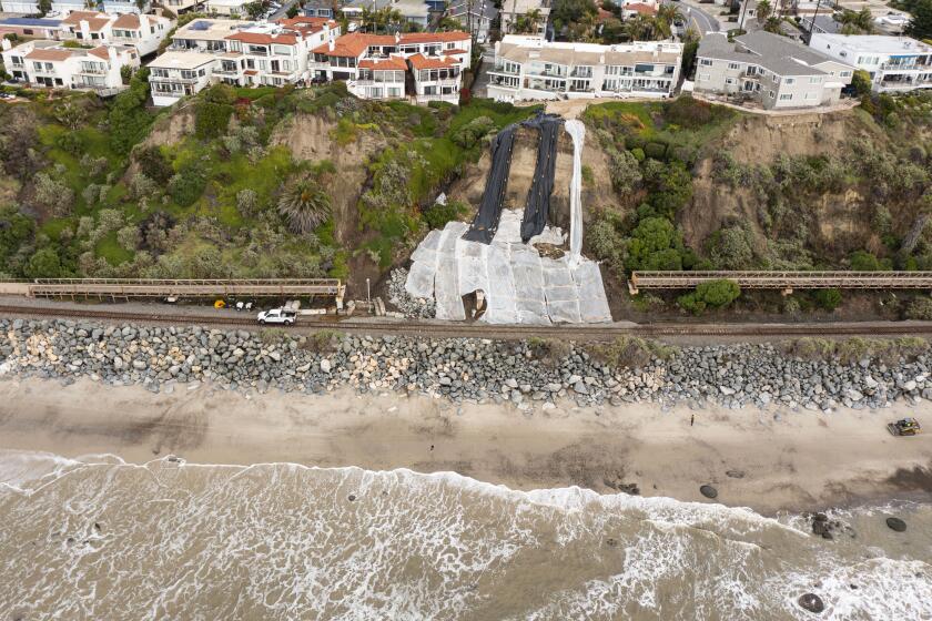 San Clemente, CA - February 7: Rail service though San Clemente has been shut down since a landslide collapsed the Mariposa Pedestrian Bridge which went sliding to the railroad tracks. Here, plastic sheeting covers the area on Wednesday, February 7, 2024. (K.C. Alfred / The San Diego Union-Tribune)
