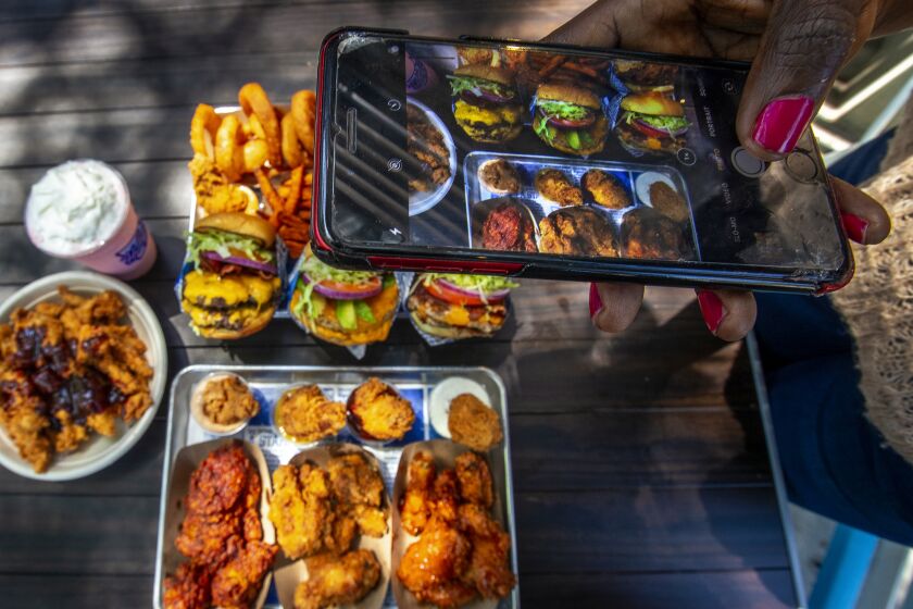 WEST HOLLYWOOD, CA-MAY 13, 2022: Nkechi Ahaiwe, a food influencer based in Los Angeles who runs the Instagram account @eatwhateveryouwant with 63.5K followers films content at the West Hollywood location of Hollywood Burger. (Mel Melcon / Los Angeles Times)