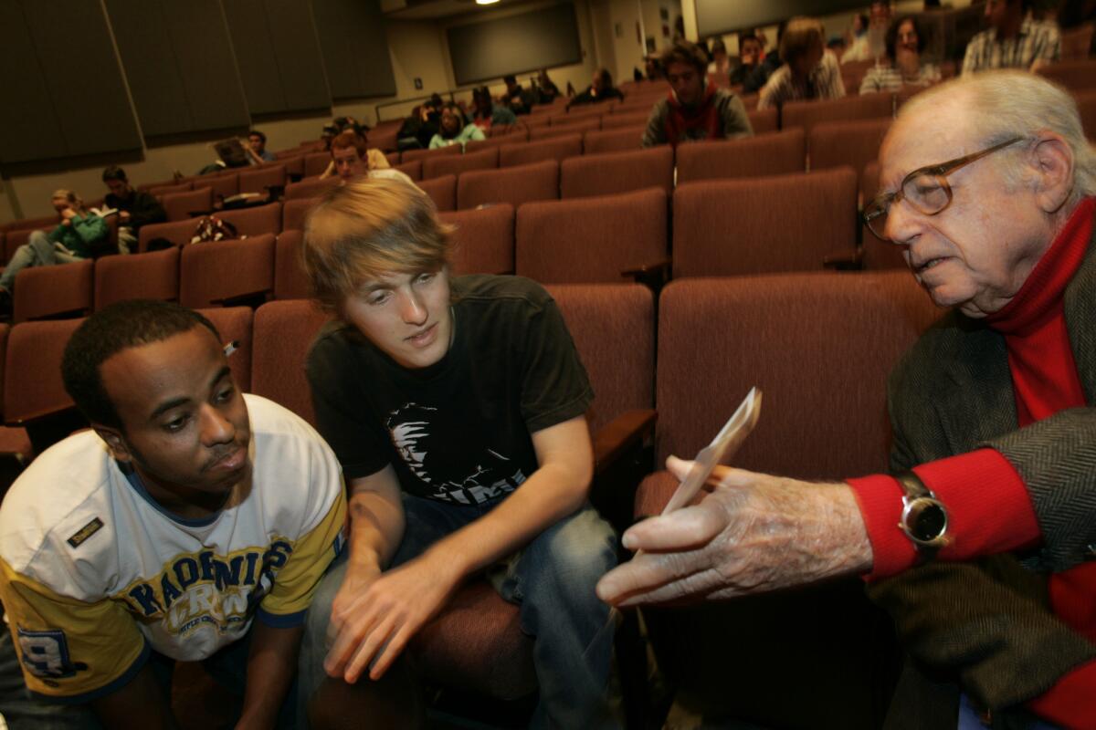 Writer-producer Stanley Rubin, right, speaks with fellow UCLA students Elias Male, left, and Marshall Knight in 2005.