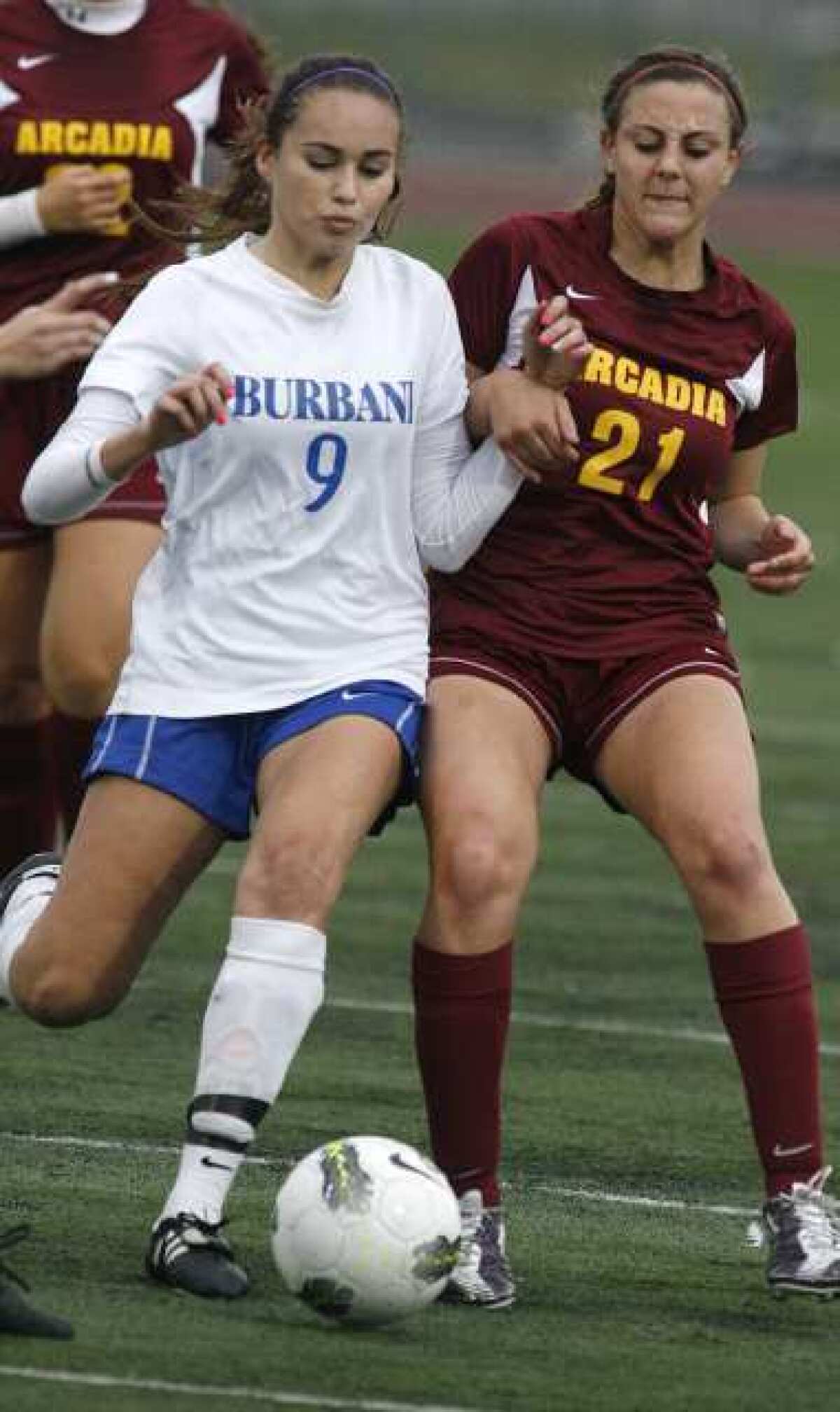 Burbank's Dakota Briseno battles for the ball against Arcadia's Mickey Cappello.