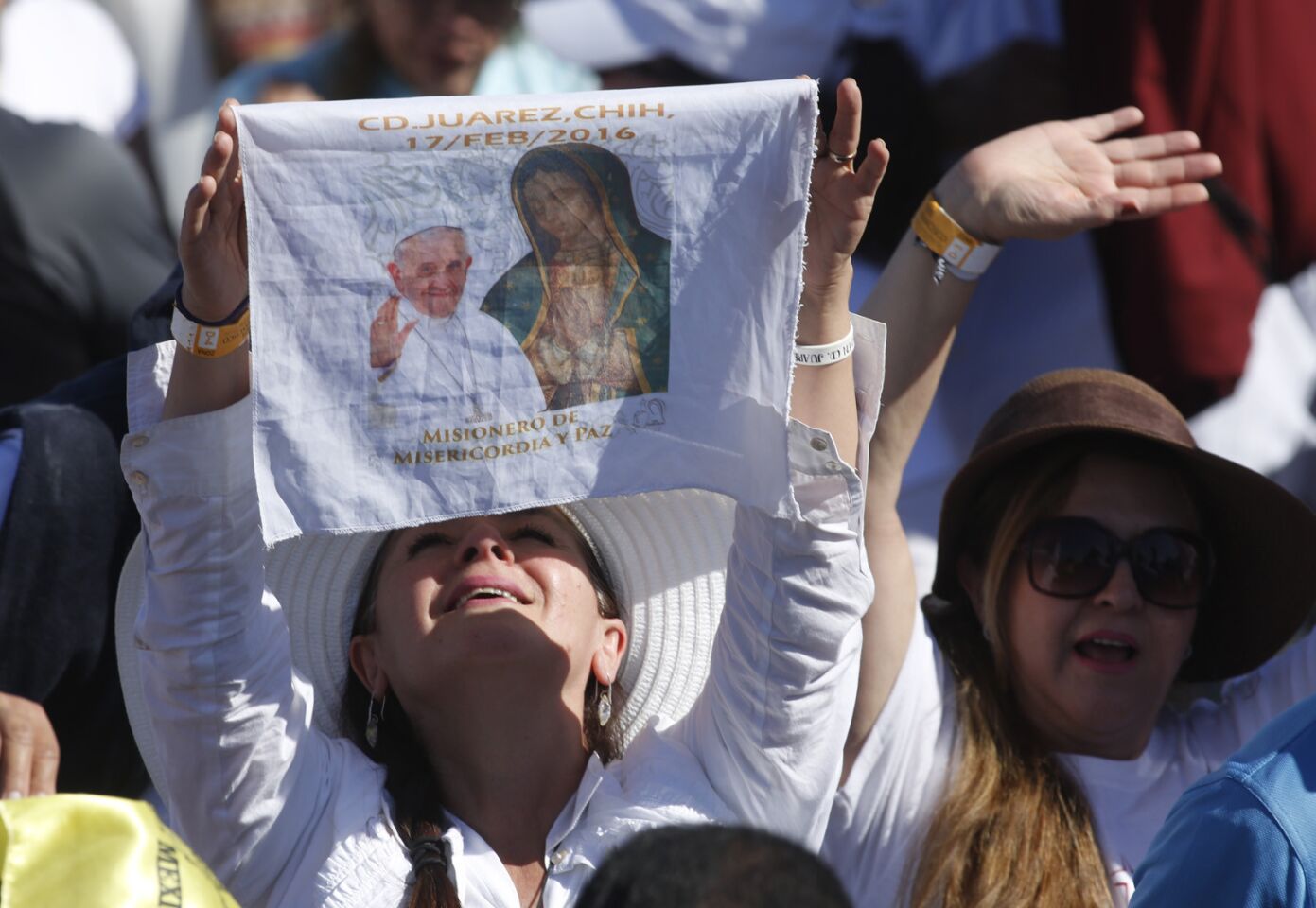 People react as Pope Francis prays Wednesday in support of migrants from a cross-shaped altar looking over the Rio Grande toward El Paso, Texas, at El Punto fairgrounds in Ciudad Juarez, Mexico.