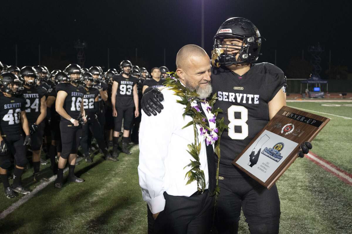 Servite's Maxx Silao (8) and coach Troy Thomas hold the Southern Section Division 1 runner-up plaque.