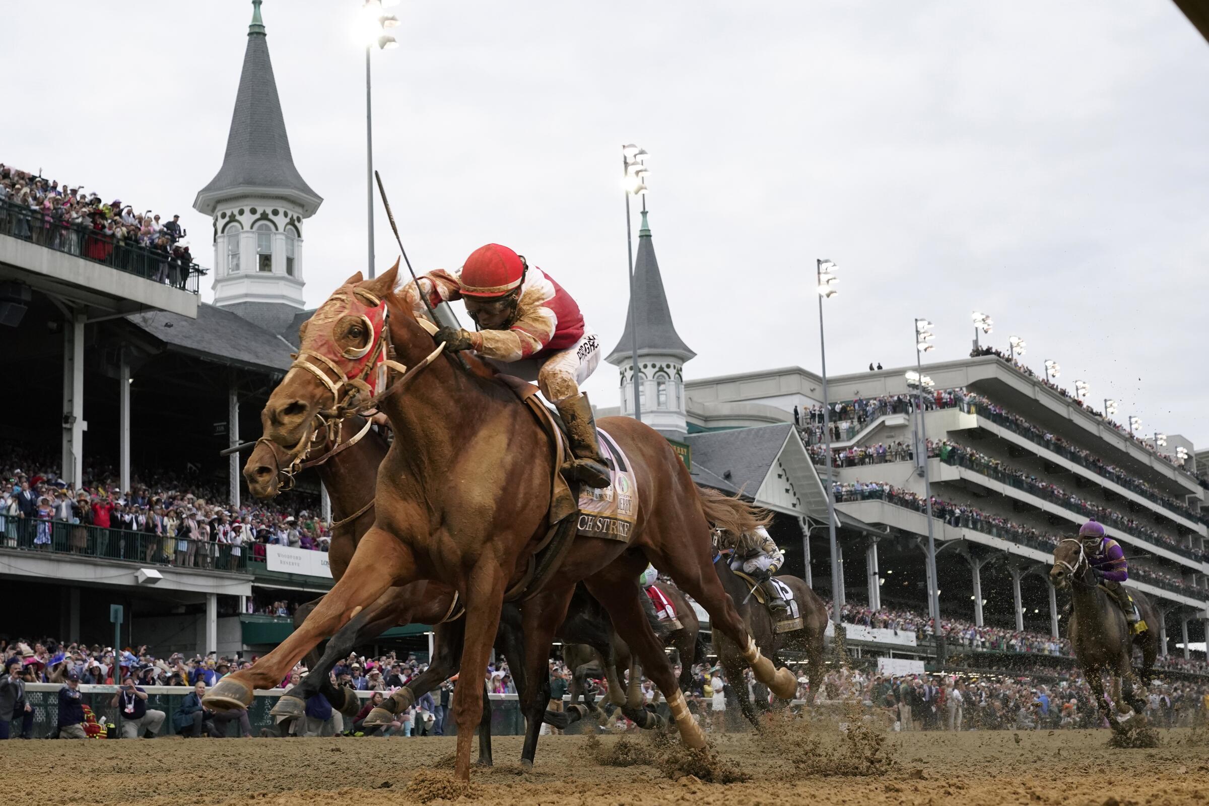 Rich Strike, with Sonny Leon aboard, crosses the finish line to win the 148th running of the Kentucky Derby.