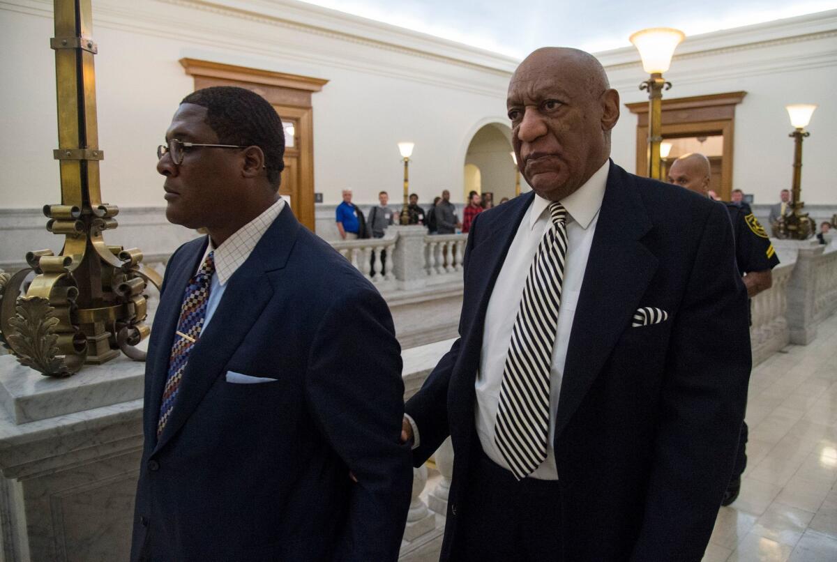 Bill Cosby, right, returns to court Monday after a lunch break during a pretrial hearing in his sexual assault trial in Norristown, Pa.