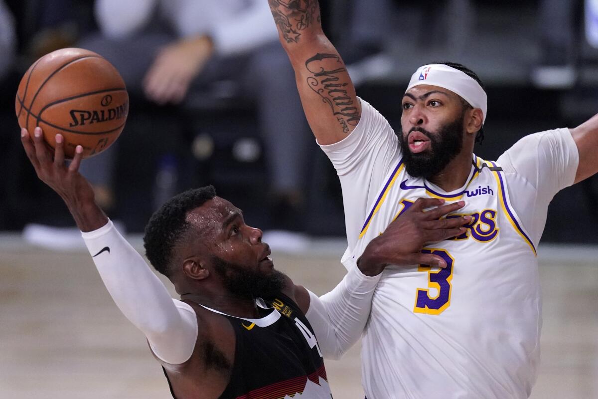 Lakers forward Anthony Davis tries to block a shot by Nuggets forward Paul Millsap during the second half of Game 3.