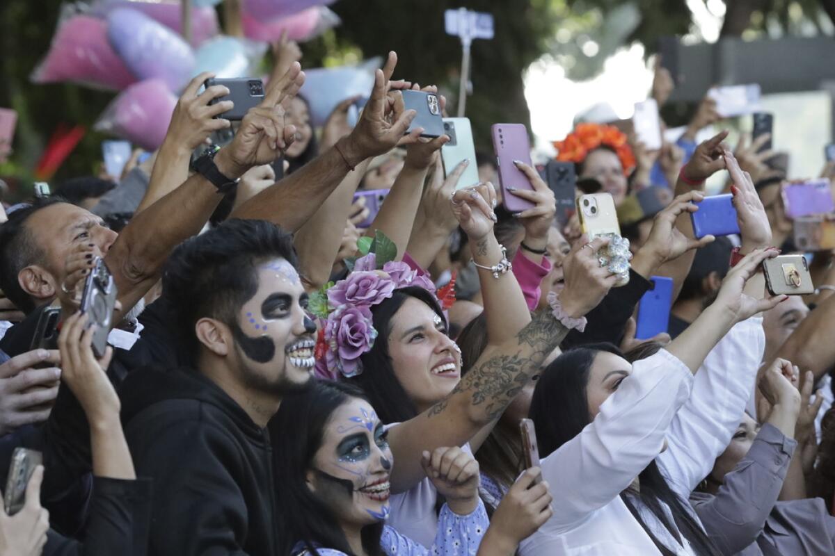 Los espectadores toman fotografías de un desfile