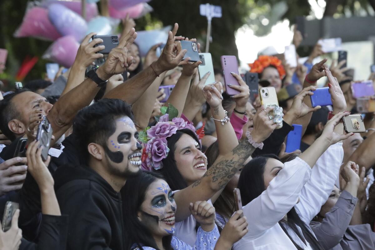 Los espectadores toman fotografías de un desfile 