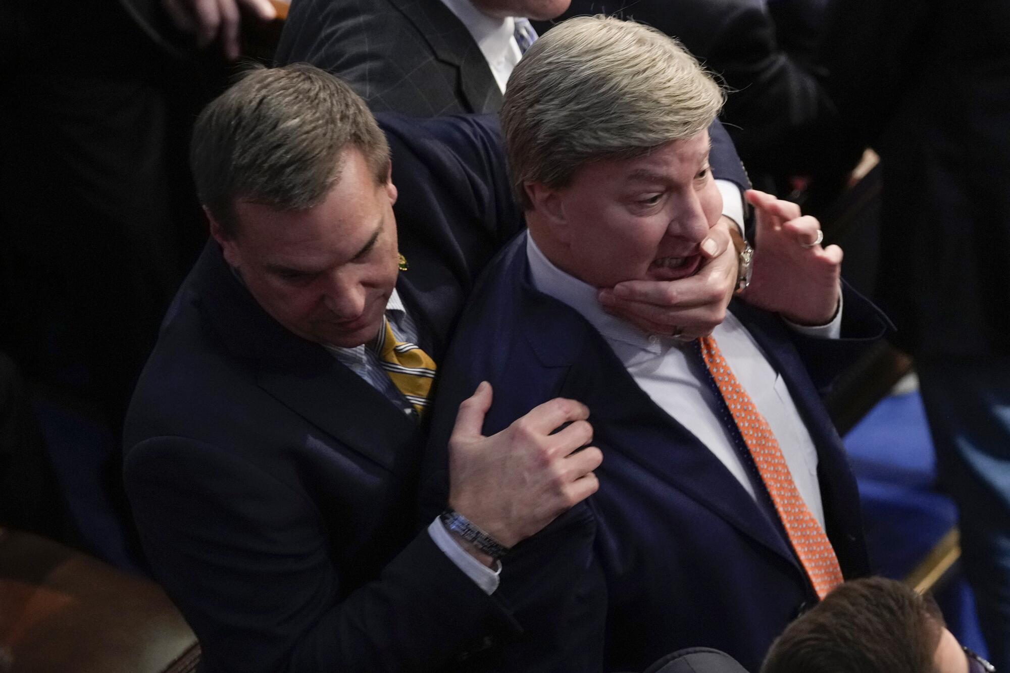 A lawmaker holding another by the chin